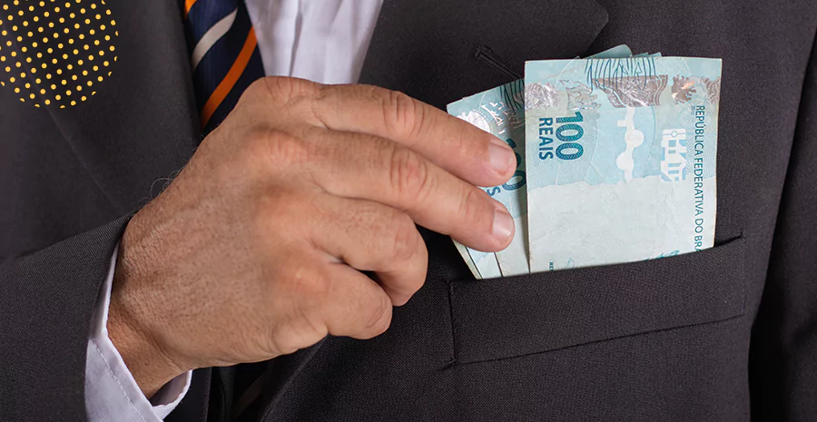 imagem de um homem colocando notas de cem reais no bolso de um paletó