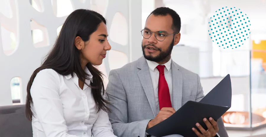 imagem de um homem e uma mulher conversando e olhando para uma prancheta