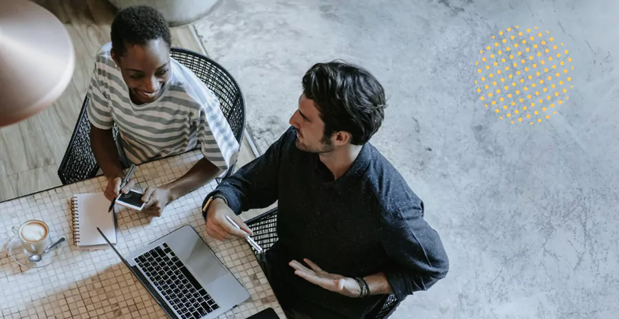 imagem de um homem e uma mulher sentados na frente de um computador conversando