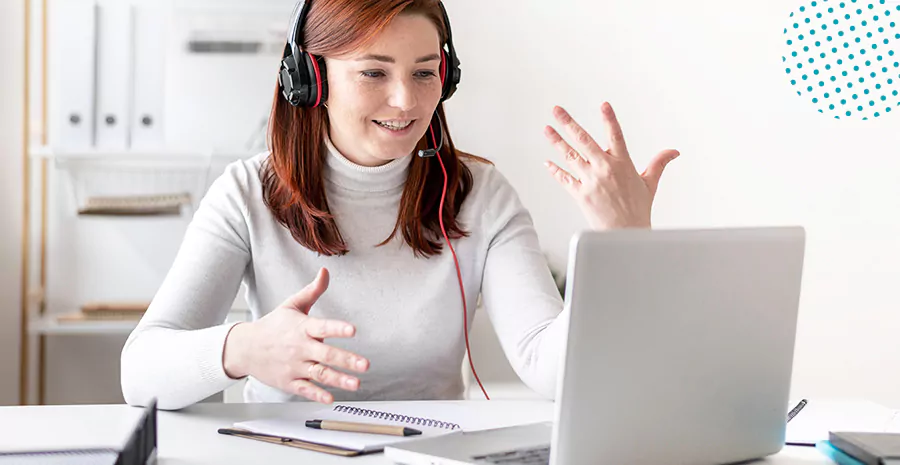 imagem de uma mulher sentada na frente de um computador usando fones de ouvido