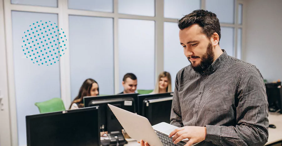 imagem de um homem sentado em um escritório segurando um computador