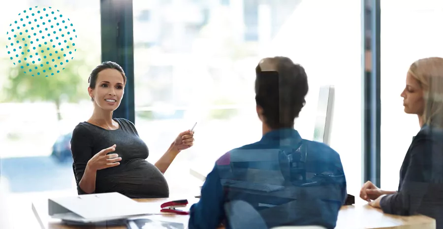 imagem de uma mulher grávida sentada falando com um homem e uma mulher sentados na sua frnte