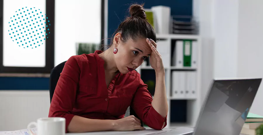 imagem de uma mulher sentada na frente de um computador com cara de preocupada
