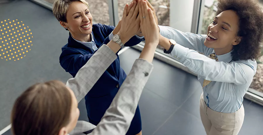 imagem de três mulheres sorrindo estendendo as mãos no centro