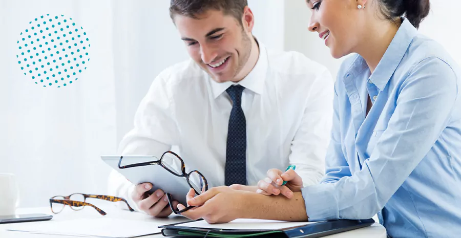 imagem de um homem e uma mulher sorrindo olhando para um tablet