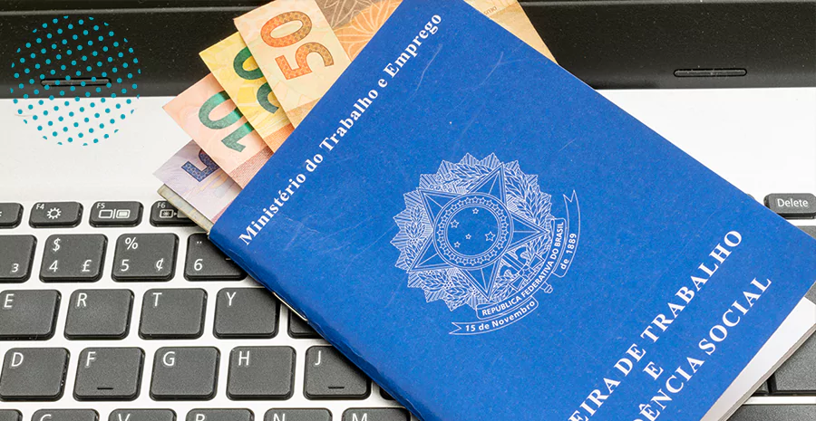imagem de uma carteira de trabalho com notas de dinheiro dentro