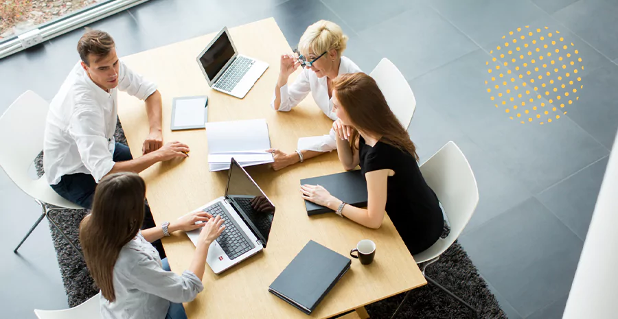 Grupo de colaboradores sentados em uma mesa conversando