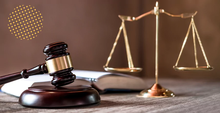 Um materlo ao lado de uma balança símbolo da justiça