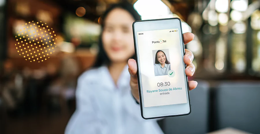 Uma mulher apresentando o celular com a tela de confirmação de registro do ponto por biometria facial