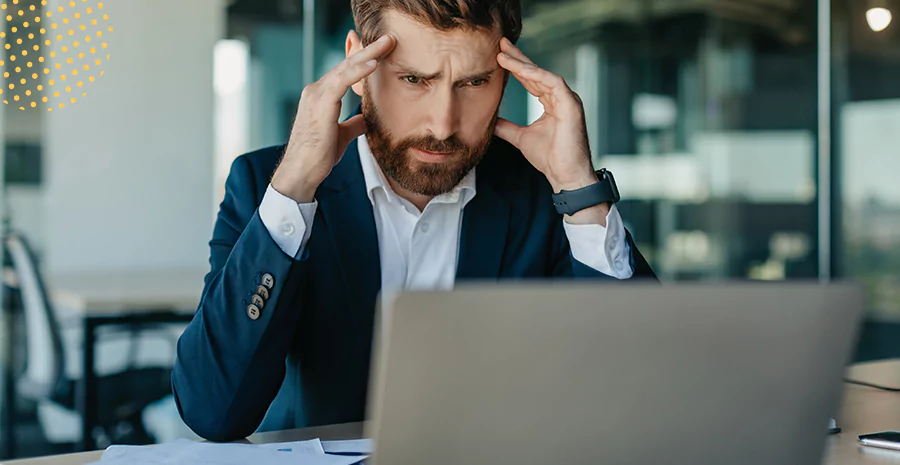 Um homem com o semblante de preocupando observando um notebook