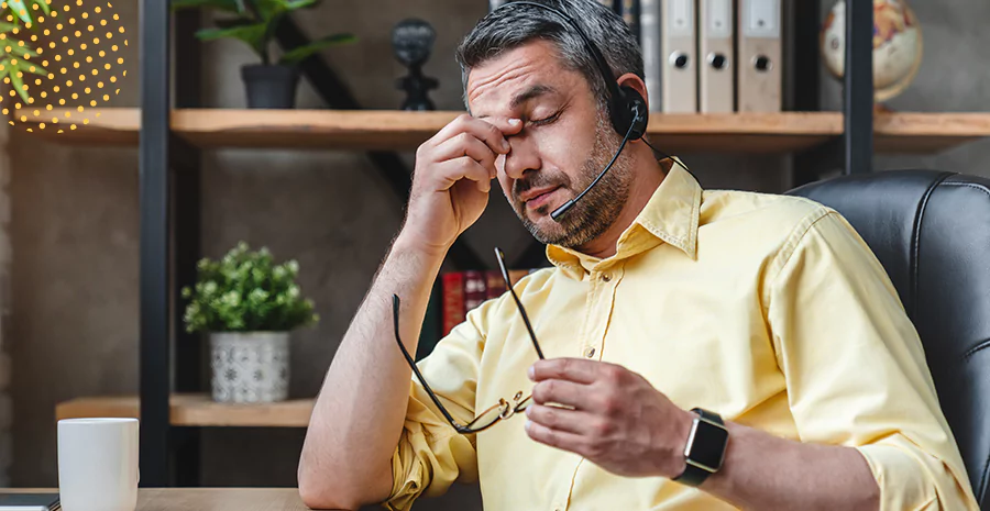 Um homem com a expressão de cansado colocando a mão no rosto