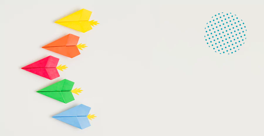 Cinco aviões de papeis com diferentes cores