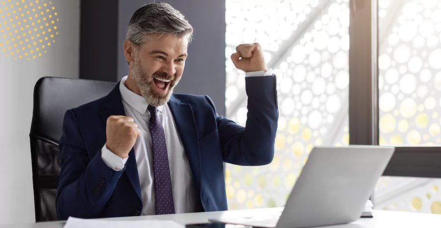 Homem comemorando em frente ao computador