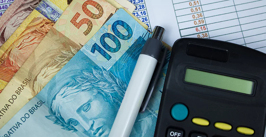 Cédulas ao lado de uma calculadora