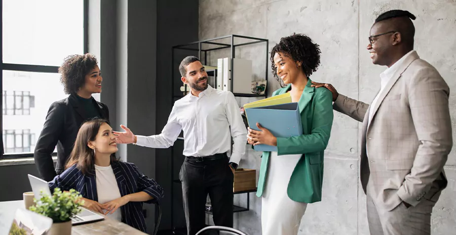 colaboradores de uma empresa em pé se cumprimentando 