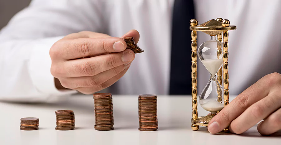 Homem segurando uma ampulheta e montes de moedas
