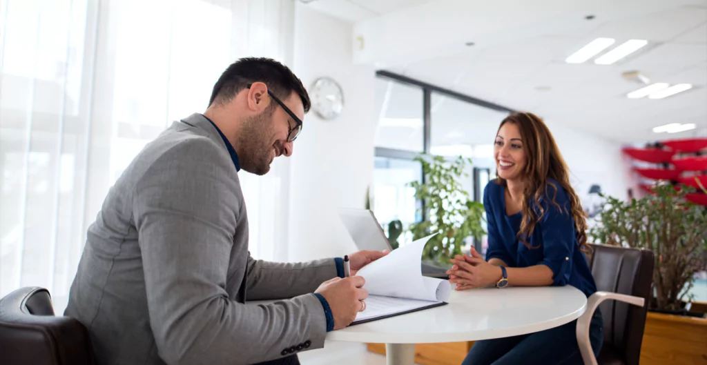 Homem anotando enquanto conversa com uma mulher