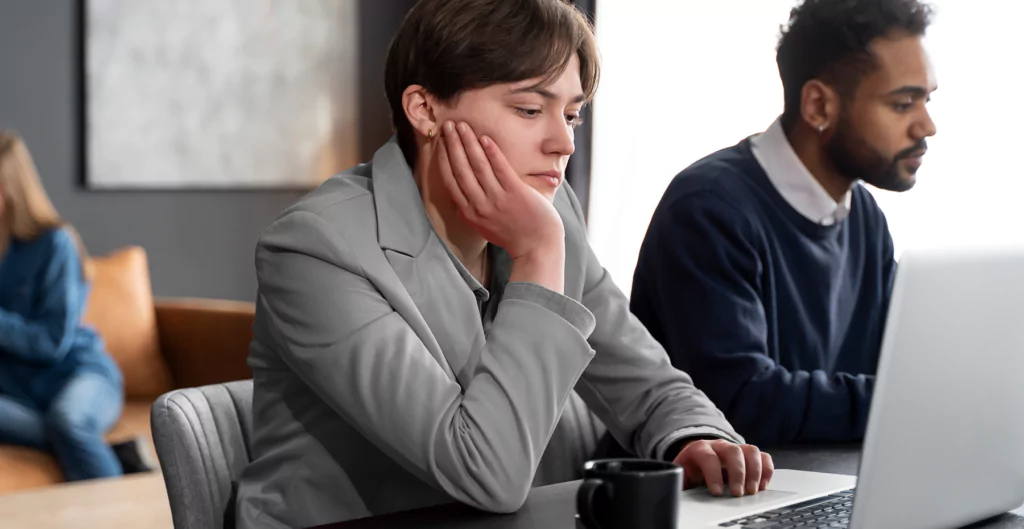 mulher em frente ao notebook com expressão de insatisfeita 