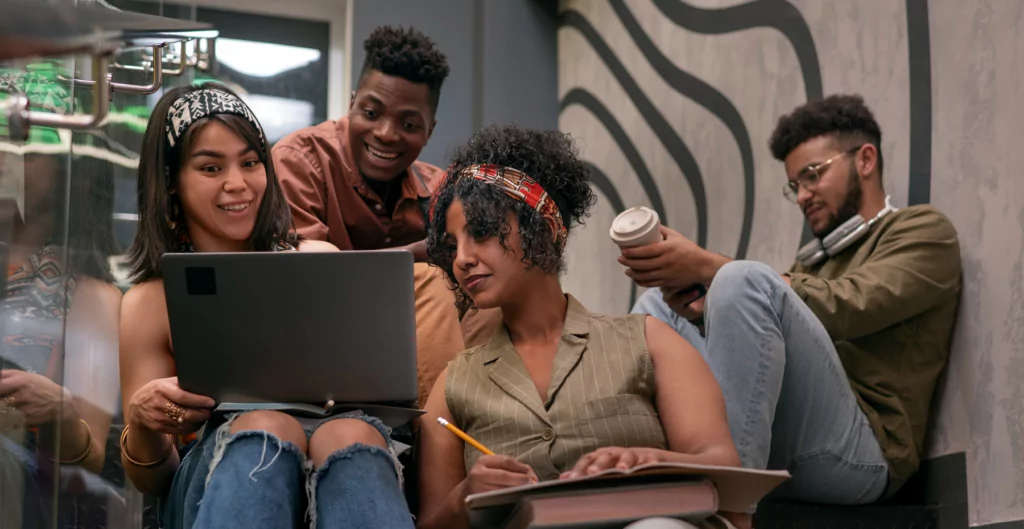 quatro alunos sentados com um laptop