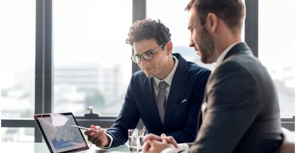 Dois homens de negócios olhando para uma tela de laptop