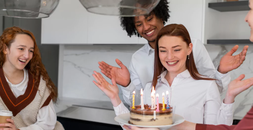 Um grupo de pessoas que celebra um aniversário com um bolo