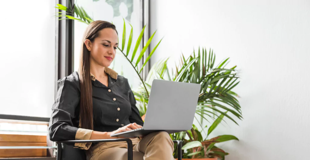 Uma mulher sentada em uma cadeira com o laptop