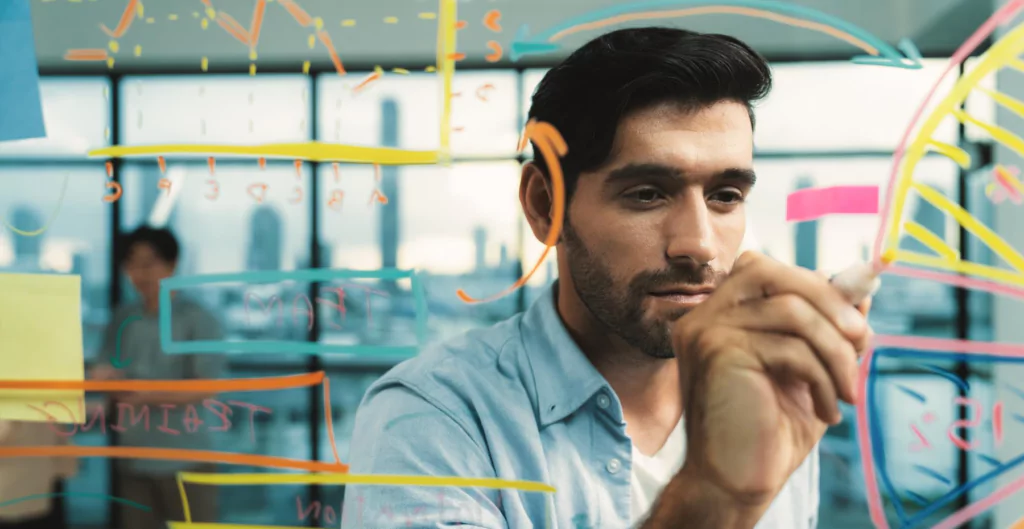 homem fazendo desenhos em quadro transparente