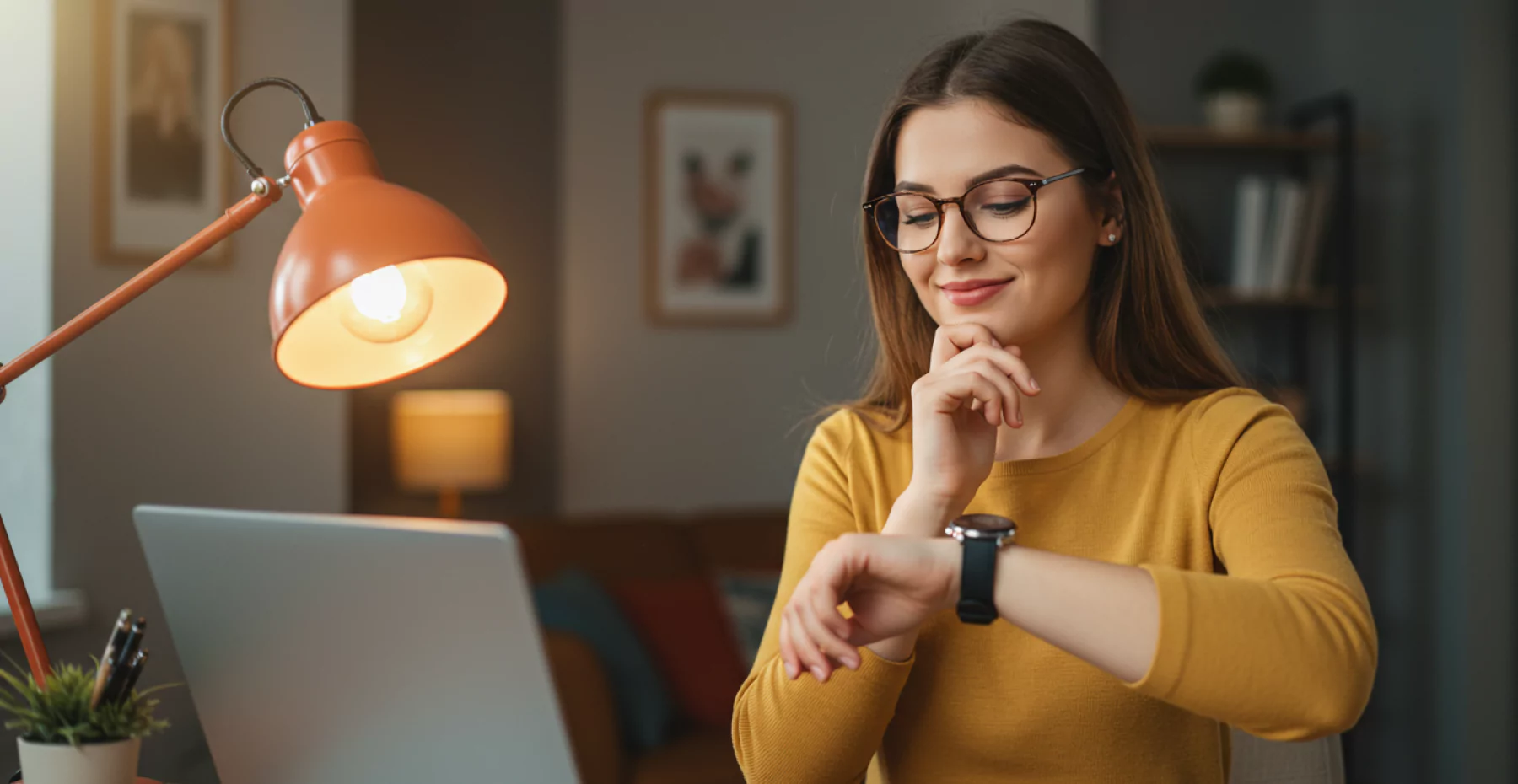 Mulher em escritório criativo, olhando para o relógio em seu pulso