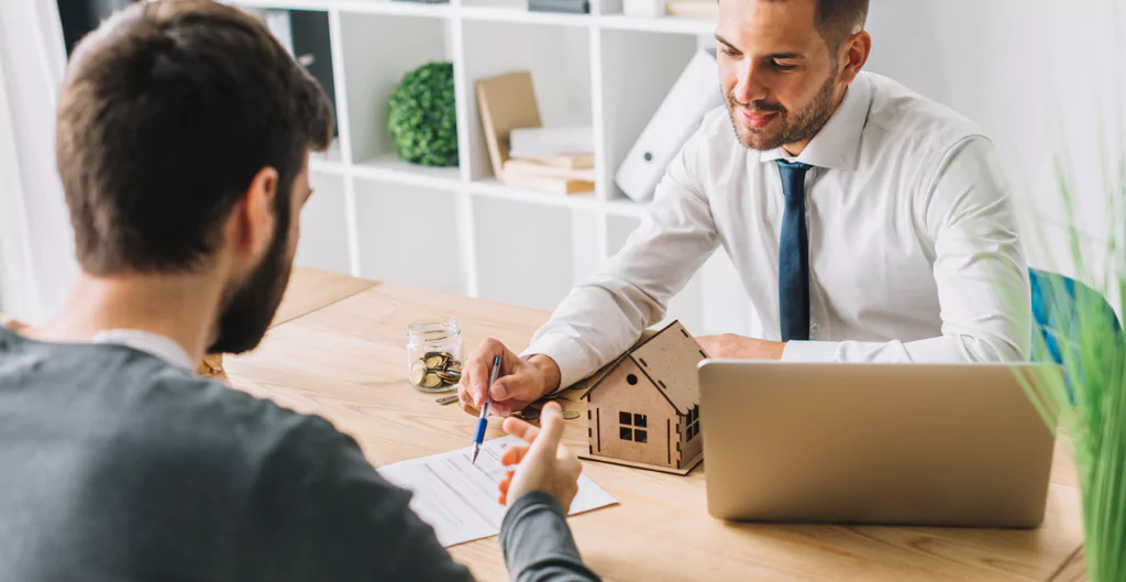 imagem mostra dois homens conversando em um escritório de imobiliária