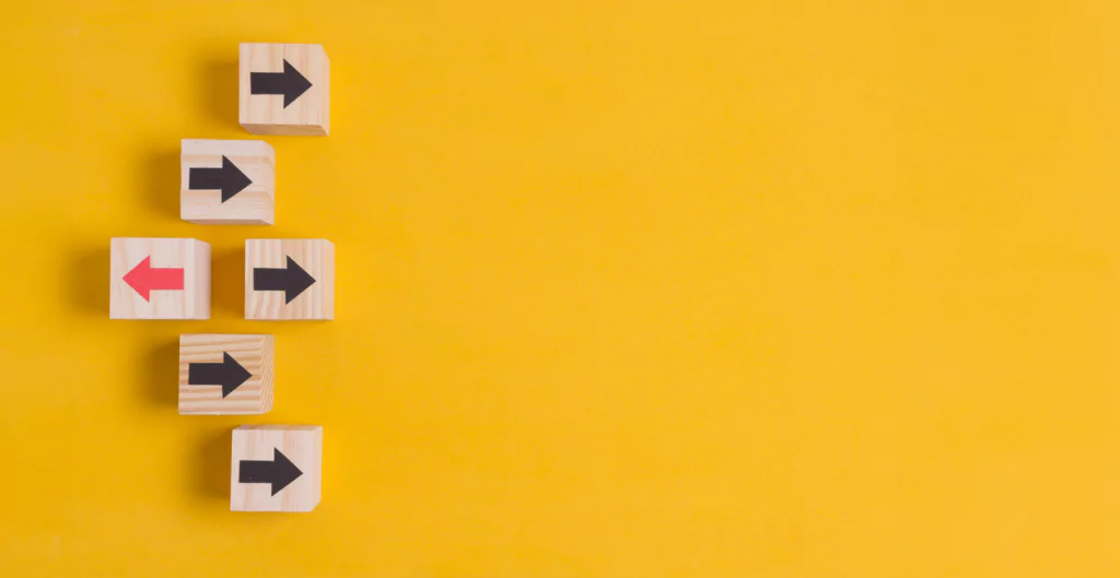 imagem mostra cubos de madeiras com setas desenhadas em cima de um fundo amarelo