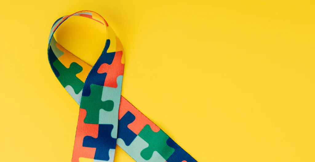 imagem mostra uma fita com o símbolo do autismo