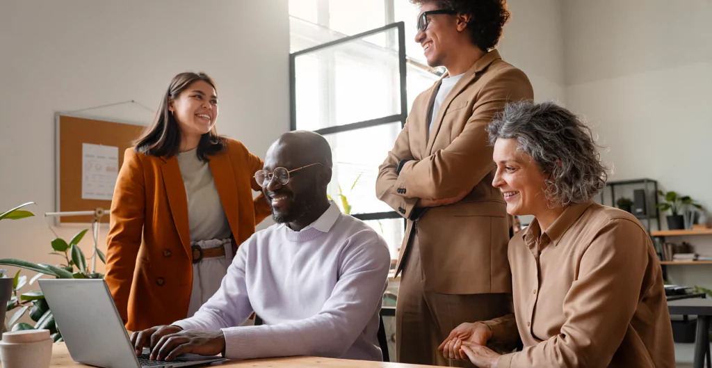 4 pessoas em uma sala, sentados à mesa debatendo sobre o gap geracional na empresa 