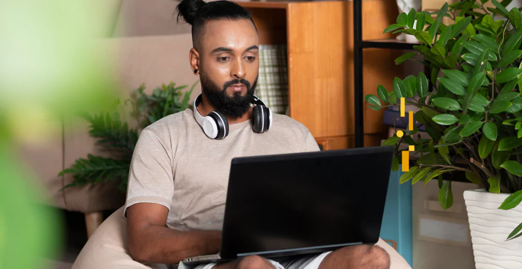 Homem trabalhando remotamente com notebook, representando marcação de ponto no home office.