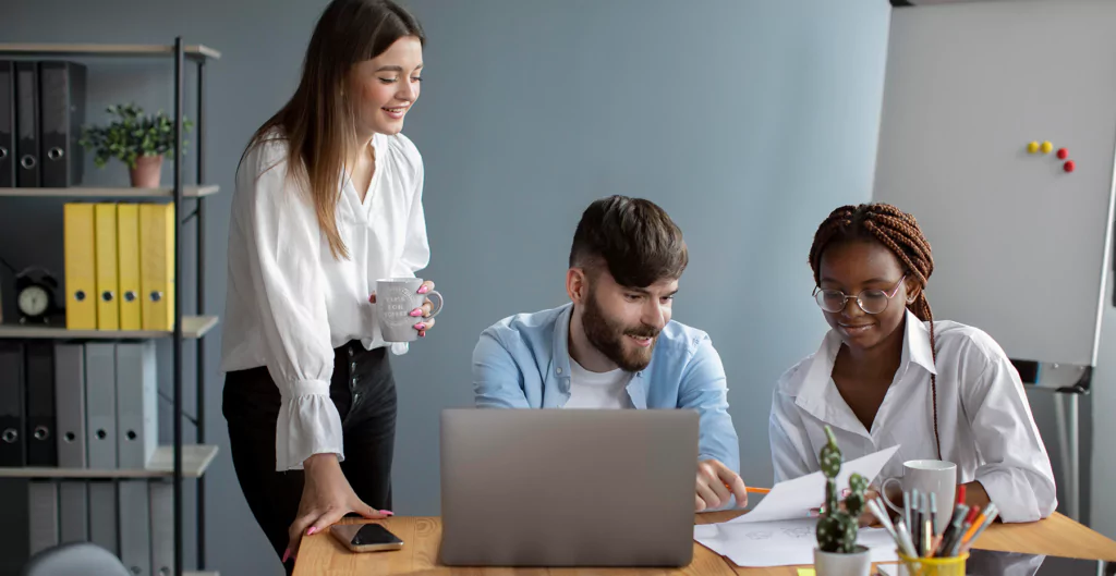 Grupo colaborando em escritório, destacando engajamento no customer success.