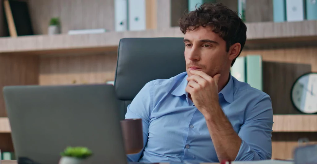 Homem analisa dados no escritório enquanto pesquisa sobre normas NR1.