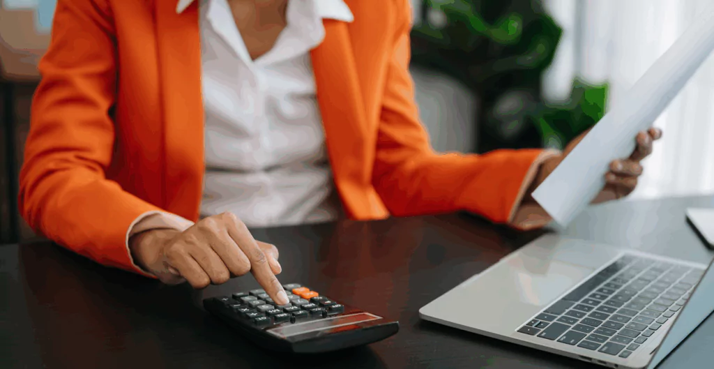 Mulher digitando em calculadora para calcular o adicional de insalubridade