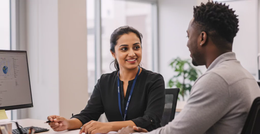 imagem de duas pessoas no trabalho conversando, representando como prevenir o abuso de poder no trabalho