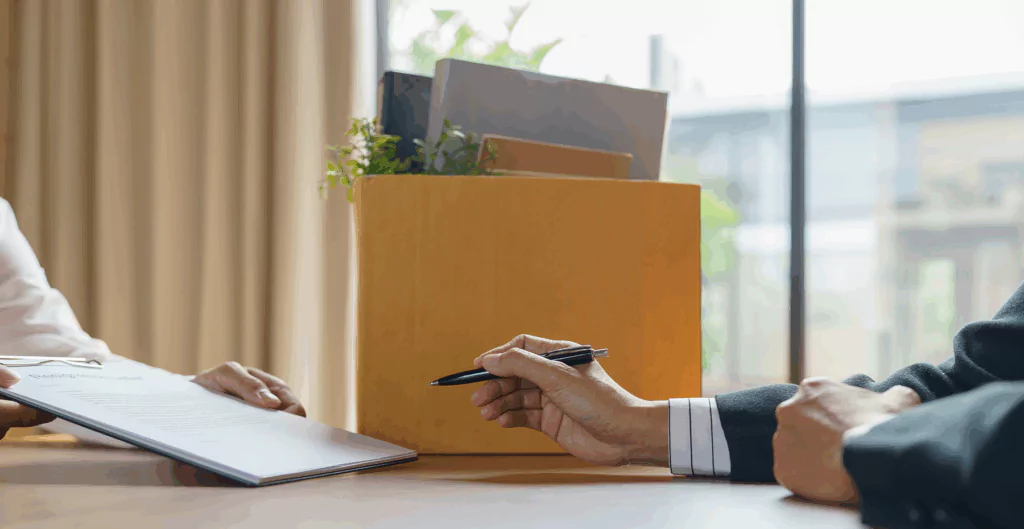 Reunião de negócios com duas pessoas trocando documentos e assinando contratos, ambiente corporativo com luz natural e escritório bem iluminado