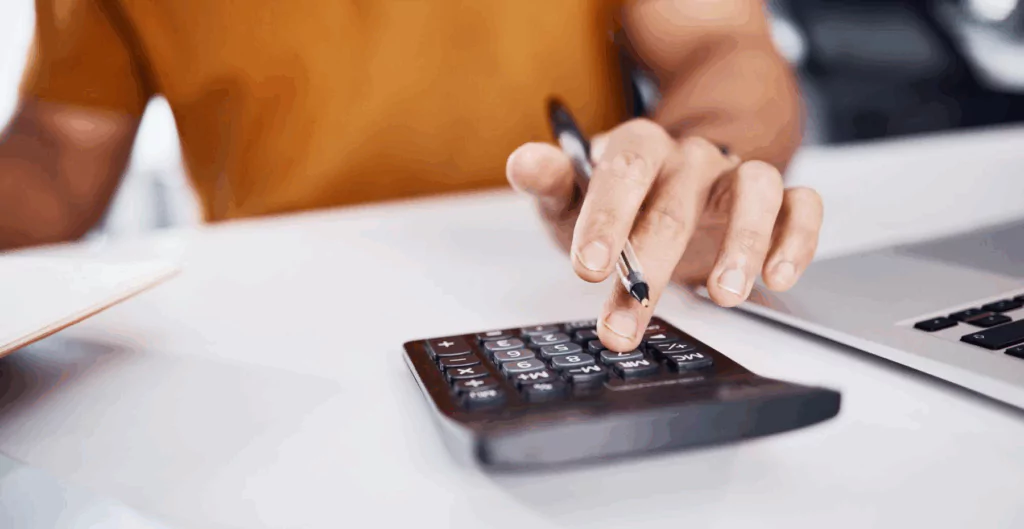 Pessoa usando calculadora para fazer cálculos financeiros ou planejamento financeiro