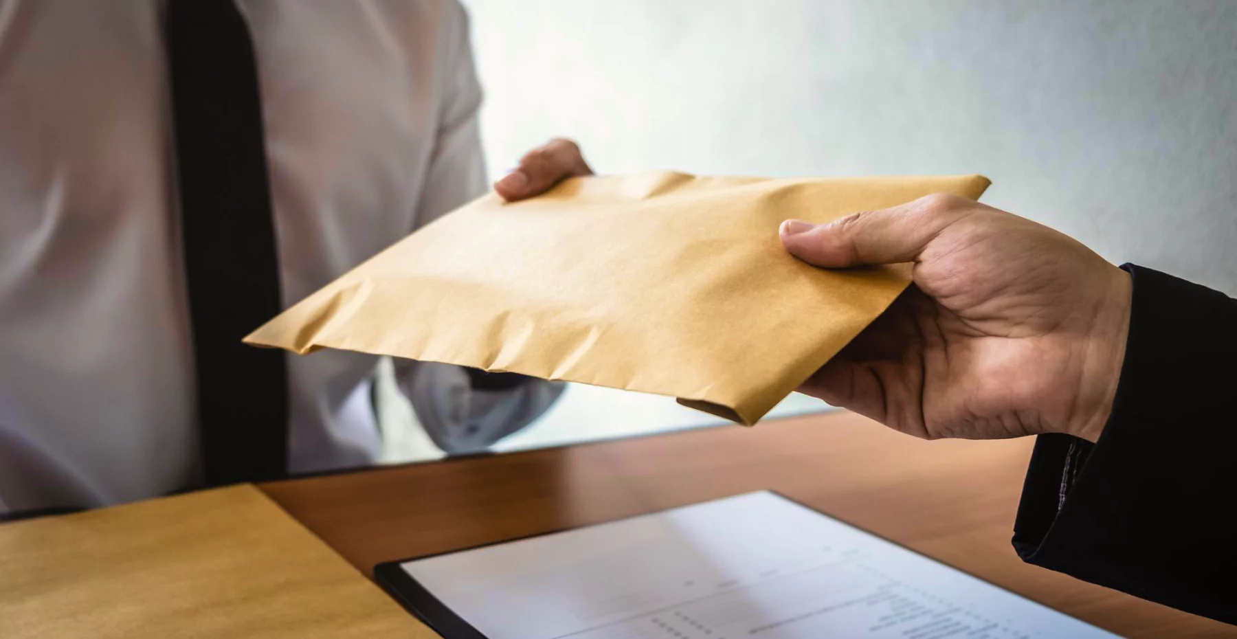 Pessoa recebendo envelope de papel pardo