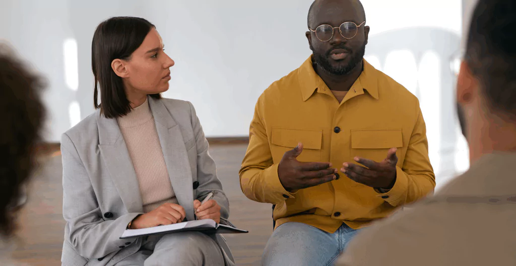 Grupo de pessoas em uma reunião de negócios discutindo estratégias e projetos para o setembro amarelo nas empresas.
