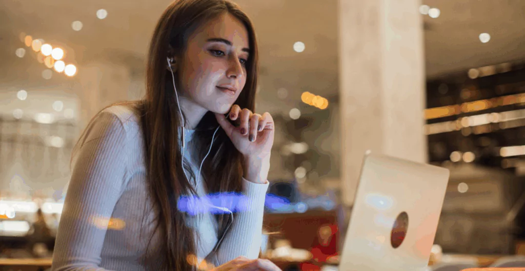 Mulher sorrindo para notebook usando fones de ouvido