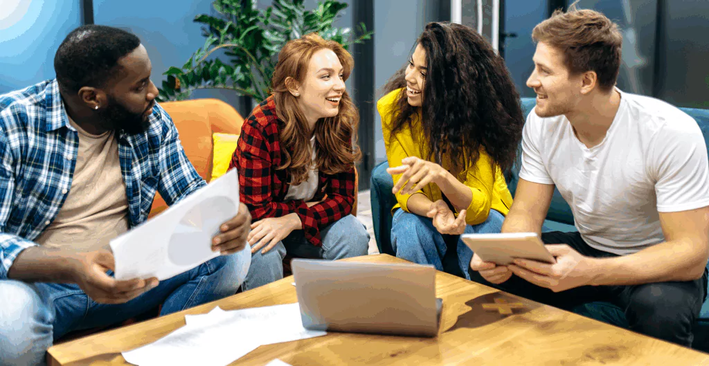 Pessoas conversando e sorrindo sentados em sofás coloridos