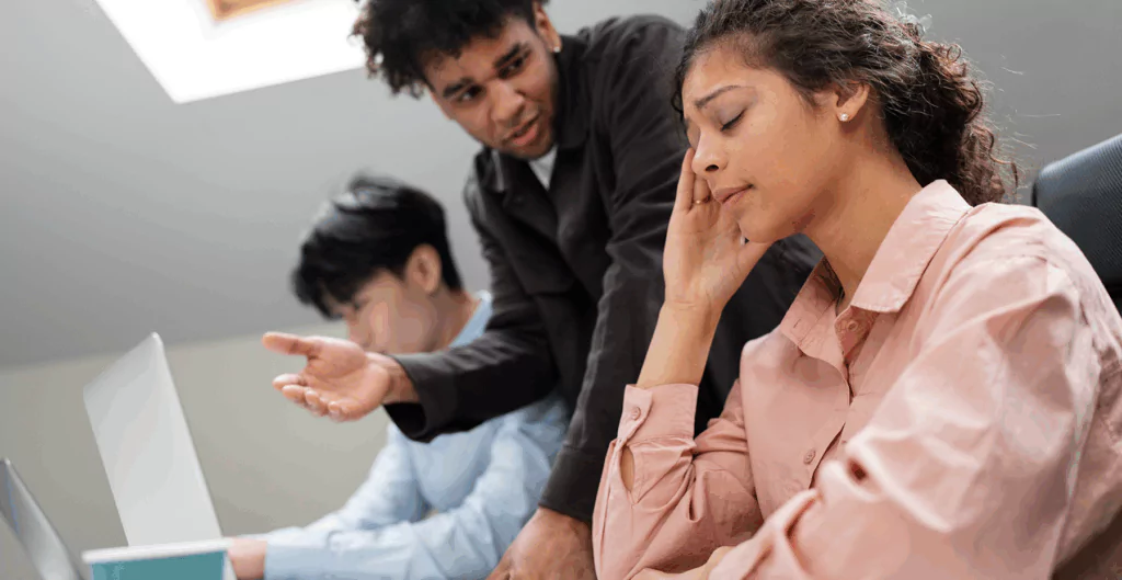 Mulher com rosto cansado, com homem ao seu lado falando 