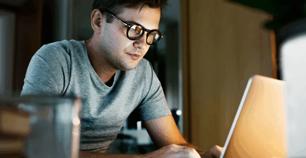 Homem digitando em notebook em home office