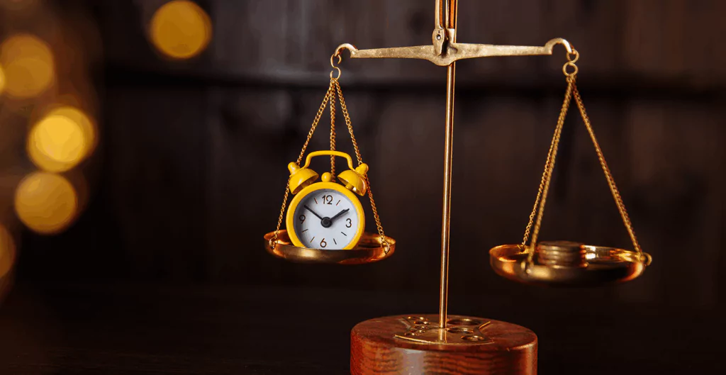 Relógio amarelo em equilíbrio na balança de precisão, simbolizando a importância de administrar o tempo eficientemente.