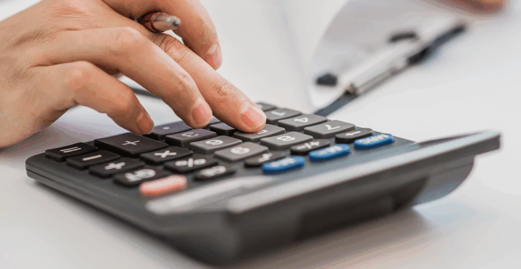 Mão digitando em calculadora 