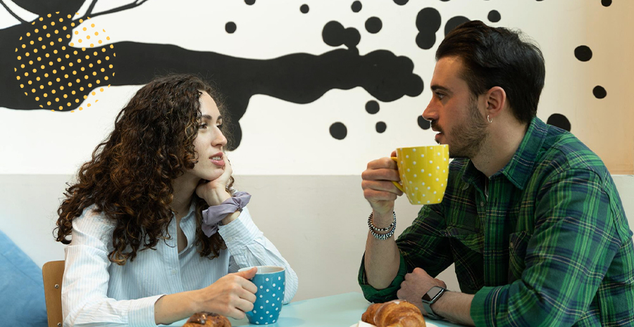 imagem de um homem e uma mulher segurando xícaras e conversando