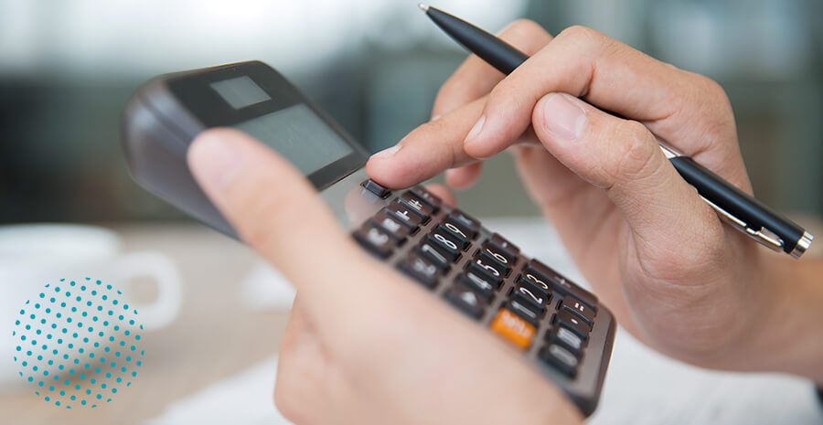 imagem de uma mão mexendo numa calculadora segurando uma caneta