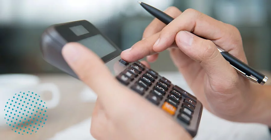 imagem de uma mão mexendo numa calculadora segurando uma caneta